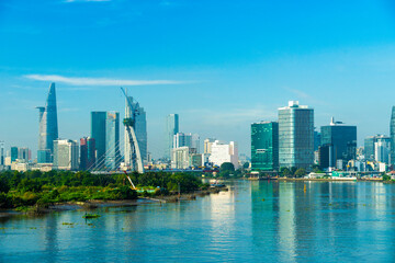 Obraz premium Aerial view of center Ho Chi Minh City, Vietnam with Bitexco Financial tower, Thu Thiem 2 bridge, buildings, energy power infrastructure. View from the Saigon river.
