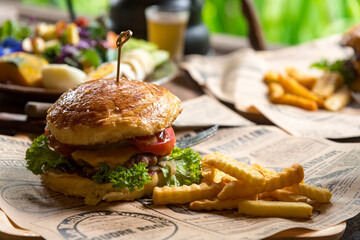Fresh homemade delicious grilled  burger with potato fries on old wooden table background board in a rustic, Side view, Close up,Selective focus .