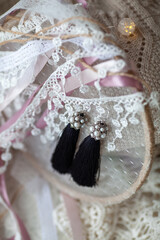 Stylish beautiful tassel earrings on lace. Fashionable accessory for the holiday.