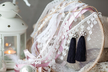 Stylish beautiful tassel earrings on lace. Fashionable accessory for the holiday.