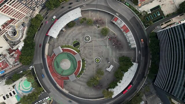 Glorieta de Insurgentes en la Ciudad de M&eacute;xico durante el d&iacute;a con flujo de transporte p&uacute;blico, autos, personas y camiones, toma a&eacute;rea con drone en la CDMX de avenida Insurgentes
