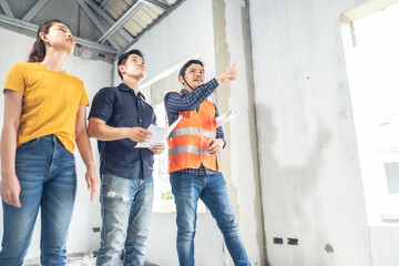 Obraz premium Young asian couple checking house with foreman engineering home inspection building house Walk home inspection with looking and pointing construction for check building home to construction 2021