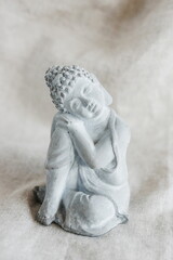 Buddha figurine in meditation on beige background. Poster