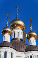 Fototapeta na wymiar Church golden domes with Orthodox crosses against the blue sky