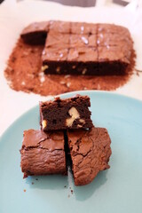 Slices of homemade brownie, selective focus.  Pieces of brownies on wooden table. Chocolate cakes with walnuts. It is called 