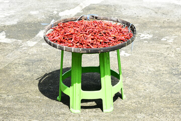 Red chilies in a tray are dried in the sun as a food preservation.