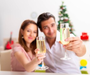 Young couple celebraring christmas with champagne