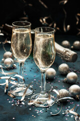 Glasses of champagne with bottle on color background, selective focus