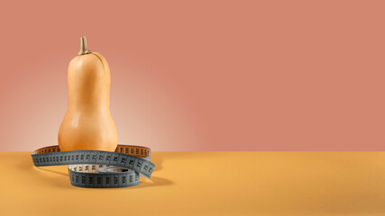 Pumpkin with a tape-measure on a colored background. Healthy food concept