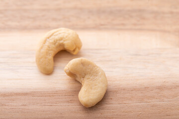 木のテーブルに置かれたカシューナッツ　
ウォールナット素材とナッツ