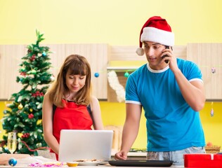 Young couple celebrating Christmas in kitchen