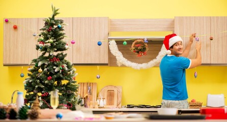 Young man celebrating Christmas in kitchen