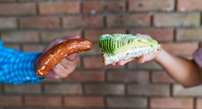 Choosing a delicious sausage or healthy avakado sandwich for morning breakfast for an energetic day