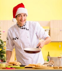 Young chef husband working in kitchen at Christmas eve