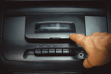 Fototapeta premium pressing buttons on a tape recorder, hand close-up