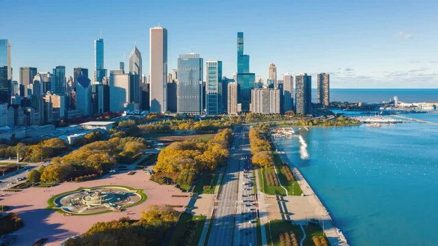 Aerial Hyperlapse of Chicago Downtown skyline and city park full of colorful trees during fall season