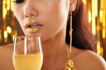 Close-up image of young woman with full sensual lips drinking cocktail at party
