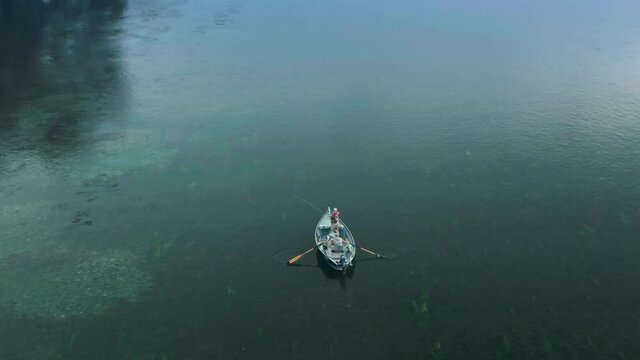 Aerial: People in a boat trout fishing in the sacramento river at sunrise.  Redding, California, USA, 