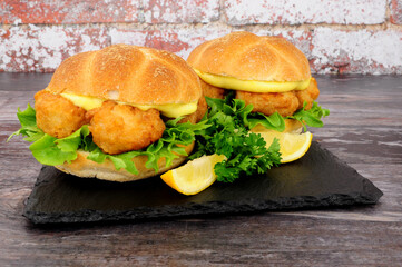 Battered cod fish nugget sandwiches with mayonnaise and lettuce in crusty bread rolls