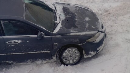 A passenger car got stuck in the snow. Wheels skid in snow on ice, close-up, wheelspin