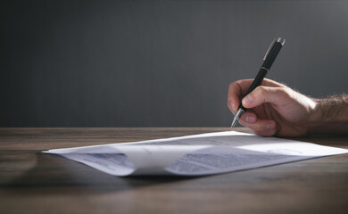 Human hand signing contract in office.