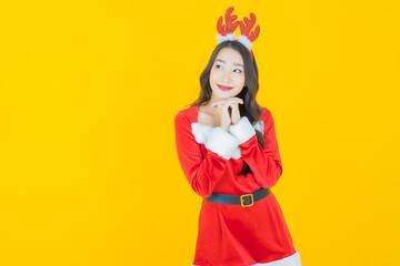 Portrait young asian woman wear christmas costume with action on yellow background