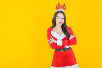 Portrait young asian woman wear christmas costume with action on yellow background
