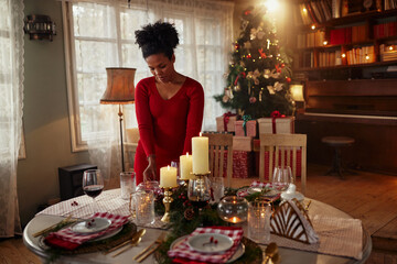 Fototapeta na wymiar Beautiful young woman decorating christmas table