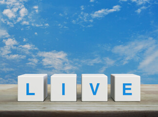 Live letter on white block cubes on wooden table over blue sky with white clouds, Technology broadcasting communication concept