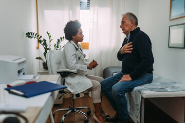Senior patient and afro doctor in hospital office