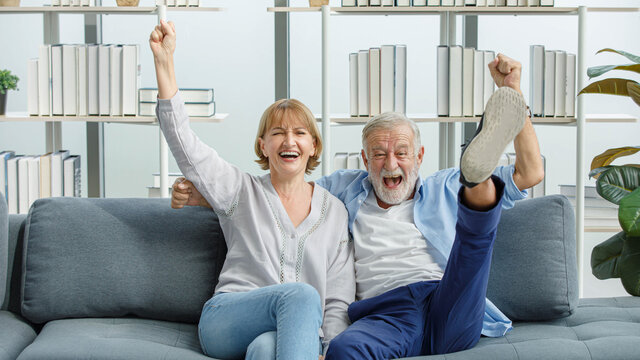 Caucasian old senior grandparents couple in casual wear gray bearded and hair husband and grandma wife sitting shouting smilingsatisfying cheering sport winning victory with excited action