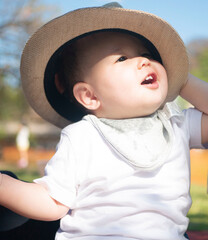 大き目の帽子をかぶるハーフの赤ちゃん - obrazy, fototapety, plakaty