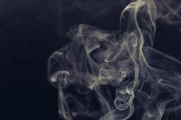 Fototapeta premium White smoke in front of the black background. 
