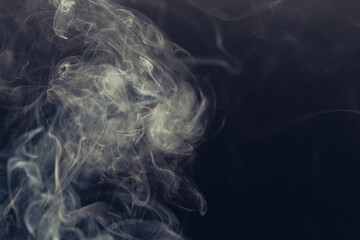 White smoke in front of the black background.	
