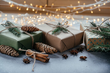 Christmas zero waste packaging gift boxes with pine cones, wooden eco decor and Christmas lights