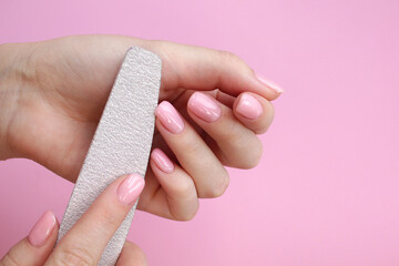 Woman hands, nail polish, manicure tools table top view flat lay. How to do manicure at home concept. Do manicure by yourself staying at home. Self care. Nude nails. Spa, medicine advertisement.