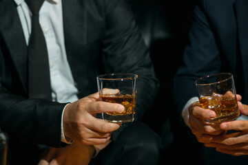 Businessmen in suits drinking whiskey