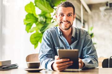 Hipster man relaxing using digital tablet computer and looking at screen relaxing with device work...