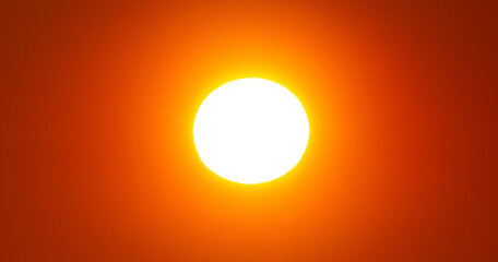 The sun shining brightly in an orange sky