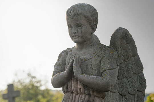 Little angel boy pray. Stone statue. (concept children's mortality)