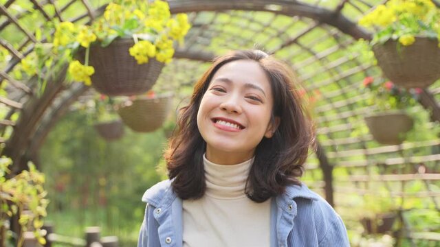 Beautiful Charming young asian woman looking at camera smile walking in the garden veranda slow motion 4k clip