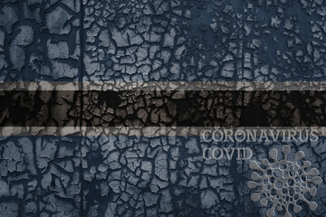 flag of botswana on a old metal rusty cracked wall with text coronavirus, covid, and virus picture.