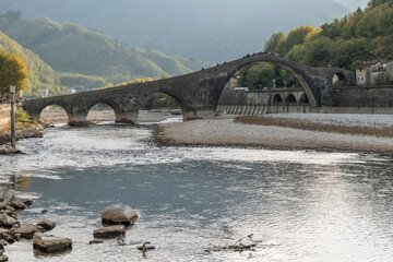 The river Serchio flows under the Ponte della Maddalena or del Diavolo, Borgo a Mozzano, Lucca,...
