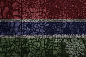 flag of gambia on a old metal rusty cracked wall with text coronavirus, covid, and virus picture.