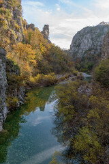 Naklejka na ściany i meble view from Kokori's old arch stone bridge (Noutsos) during fall season situated on the river of Voidomatis in Zagori, Epirus Greece.