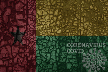 flag of guinea bissau on a old metal rusty cracked wall with text coronavirus, covid, and virus picture.