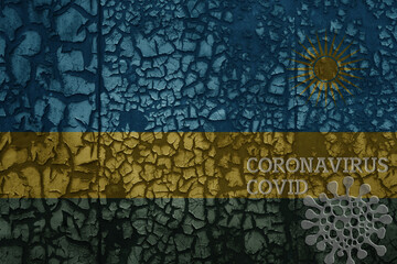flag of rwanda on a old metal rusty cracked wall with text coronavirus, covid, and virus picture.