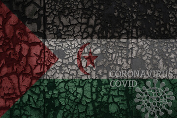 flag of Sahrawi Arab Democratic Republic on a old metal rusty cracked wall with text coronavirus, covid, and virus picture.