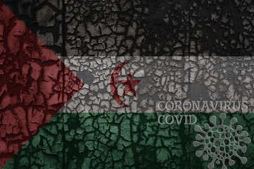 flag of Sahrawi Arab Democratic Republic on a old metal rusty cracked wall with text coronavirus, covid, and virus picture.