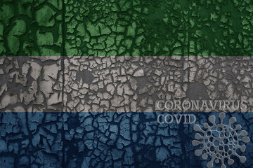 flag of sierra leone on a old metal rusty cracked wall with text coronavirus, covid, and virus picture.